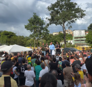 Ao centro, em um palco, estão o deputado federal Nikolas Ferreira, o vice-governador de Minas Gerais, Mateus Simões, o prefeito de Ponte Nova, Milton Irias, e demais lideranças. No centro, centenas de apoiadores acompanham os discursos.