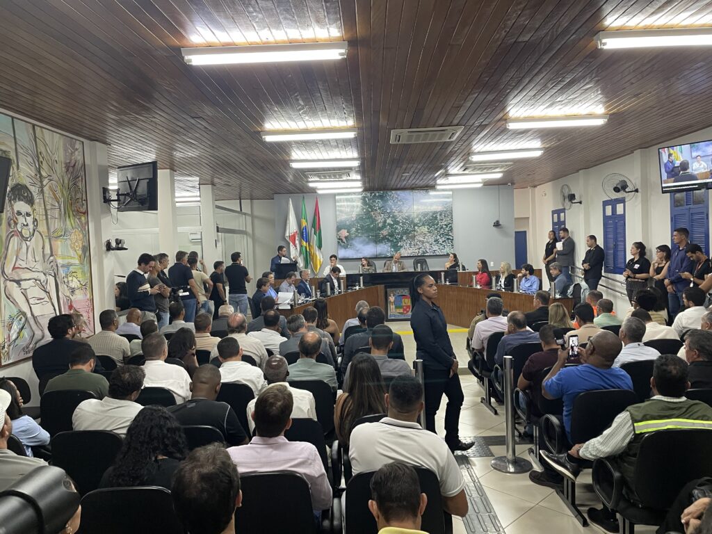 Plenário da Câmara Municipal, com os assentos totalmente ocupados, com a mesa de abertura à frente